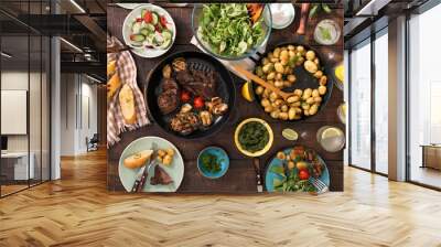 dinner table with grilled steak, vegetables, potatoes, salad, snacks, lemonade Wall mural