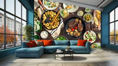 Dinner table with meat grill, roast new potatoes, different food Wall mural