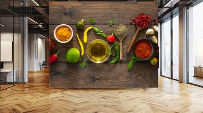 Food cooking ingredients background with various herbs, spices and olive oil on wooden background top view Wall mural