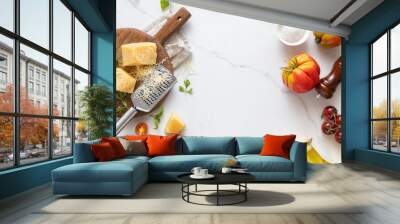 Frame of food cooking ingredients background with fresh vegetables, herbs, spices olive oil and cheese on white stone table top view. Healthy vegetarian eating Wall mural