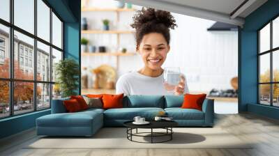 healthy lifestyle concept. beautiful young afro american woman holding a glass of clean fresh water  Wall mural