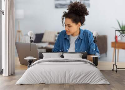 Online education concept. Beautiful concentrated African American woman freelancer working from home. Happy female student using laptop computer, studying, distance learning Wall mural