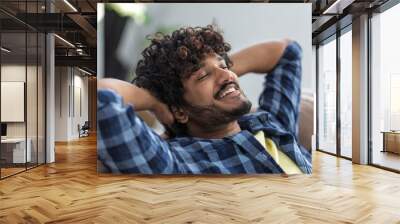 Relax at home, positive thinking concept. Portrait of happy asian man lying on sofa resting. Young male throwing his hands behind his head thinks of something good and smiles Wall mural