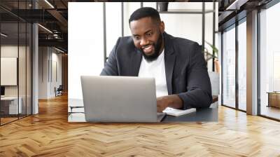 Successful young African American businessman using laptop for video communication with employees. Video conferencing or online education concept Wall mural