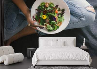 woman eating salad drinks water lemon sitting bed home Wall mural