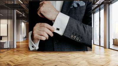 Man in suit hold his white shirt with cuff links. Wall mural