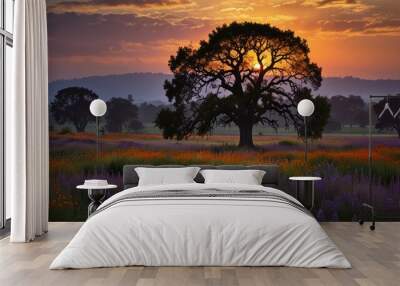 A lone tree silhouetted against a vibrant sunset, with a field of wildflowers blooming in the foreground. Wall mural