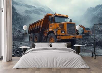 A yellow dump truck drives on a muddy road in a quarry with an excavator in the background. Wall mural