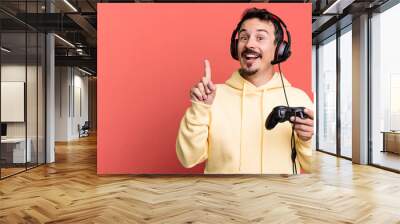 adult man feeling like a happy and excited genius after realizing an idea with headset and a control. gamer concept Wall mural