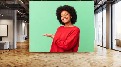 afro black woman smiling cheerfully, feeling happy and showing a concept in copy space with palm of hand Wall mural