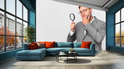 handsome businessman finfing with a magnifying glass Wall mural