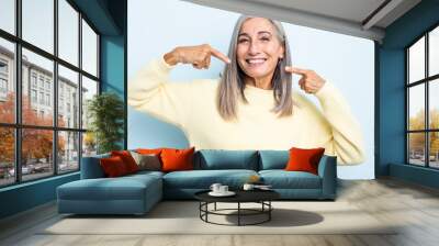 middle age gray hair woman smiling confidently pointing to own broad smile, positive, relaxed, satis Wall mural