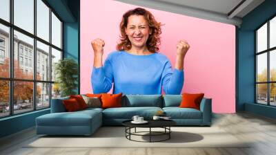 middle age hispanic woman looking extremely happy and surprised, celebrating success, shouting and jumping Wall mural