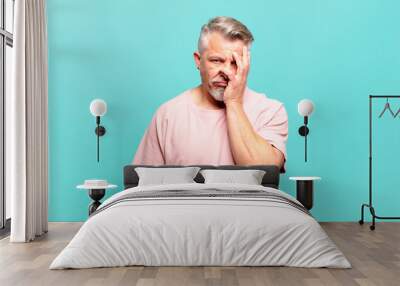 old senior man feeling bored, frustrated and sleepy after a tiresome, dull and tedious task, holding face with hand Wall mural