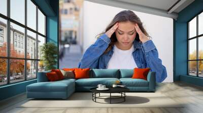 pretty hispanic woman looking concentrated, thoughtful and inspired, brainstorming and imagining with hands on forehead Wall mural