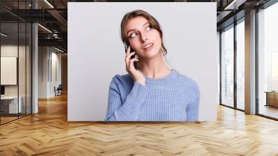 pretty young woman using a smartphone Wall mural