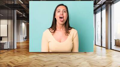 young adult pretty woman with cheerful, carefree, rebellious attitude, joking and sticking tongue out, having fun Wall mural