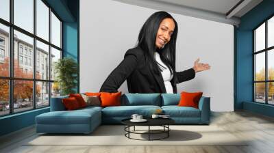 young black woman feeling happy and cheerful, smiling and welcoming you, inviting you in with a friendly gesture. business concept Wall mural