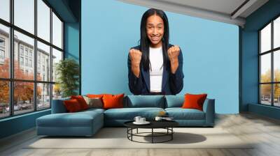 young black woman shouting triumphantly, laughing and feeling happy and excited while celebrating success. business concept Wall mural