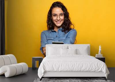 young hispanic woman smiling happily with friendly, confident, positive look, offering and showing an object or concept Wall mural