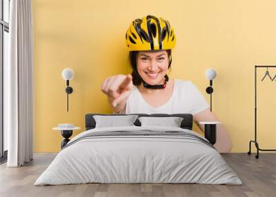 young pretty woman pointing at camera choosing you. bike helmet concept Wall mural