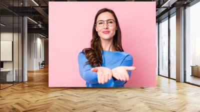 young pretty woman smiling happily with friendly, confident, positive look, offering and showing an object or concept Wall mural