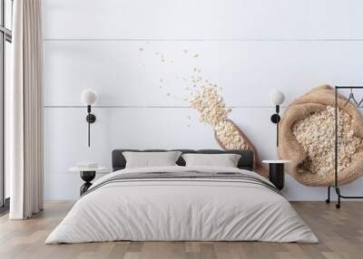 Oat flakes in sack with wood spoon on the white wooden table Wall mural