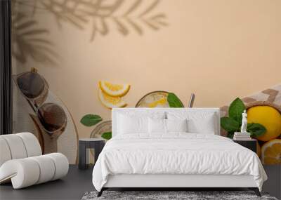 Summer layout with lemonade, fresh citrus fruits, hat and sunglasses on a beach towel on a beige background with palm leaf shadow. Wall mural