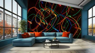 Luces brillantes de colores en movimiento con fondo oscuro Wall mural