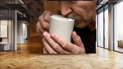 a man drinks cappuccino coffee close-up moustache in foam Wall mural