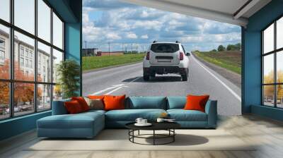 A white crossover car is driving on the road Wall mural