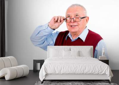 Smiling happy senior old man looking up and holds the glasses ri Wall mural