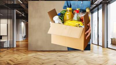 Woman hands holding cardbox with grocery products. Volunteer collecting food into donation box. Donation, charity, food bank, help for poor families, migrants, Generative AI  Wall mural