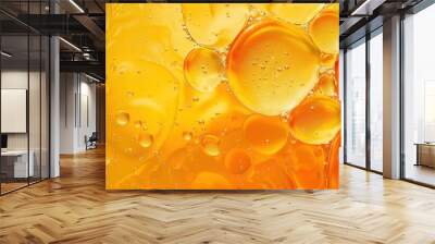 Close-up of colorful overlapping oil and water bubbles with a vibrant yellow and orange color palette. Wall mural