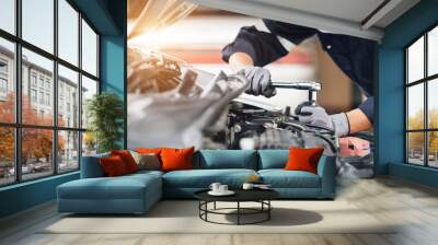 Mechanic works on the engine of the car in the garage. Repair service. Concept of car inspection service and car repair service. Wall mural