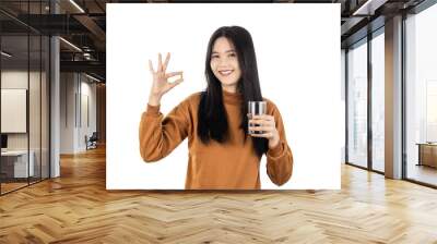 Asian Young healthy woman holding pill and glass of water isolated on white background with clipping path. Health and illness concept. Wall mural