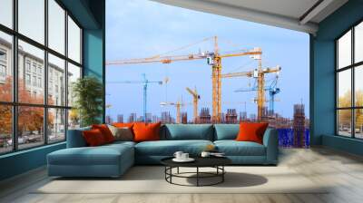 Construction site with multiple cranes on a blue background. Wall mural