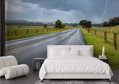 Highway road with green fields and lightning in a rainy day, landscape of a rural area... Wall mural