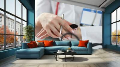 Doctor looking at wrist watch in office closeup Wall mural