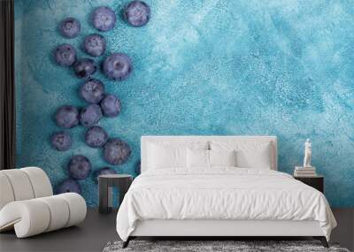 Top view of blueberries on a blue concrete or marble background (copy space on the right) Wall mural