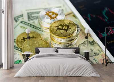 Stacks of Bitcoins on paper dollar banknotes with white modern tablet with stock market candlestick chart, virtual currency, digital crypto, metal cryptocurrency coins Wall mural