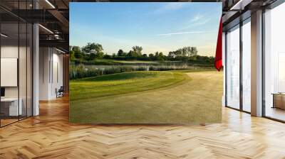 golf green with red flag on pole Wall mural