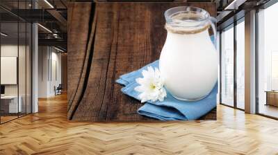 fresh milk in a glass jug on a blue napkin with a flower Wall mural