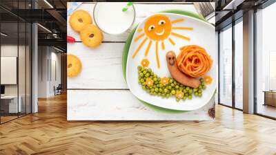 Fun food for kids - Cute little snail made of spaghetti and a sausage, served with green peas and cheddar cheese decoration Wall mural