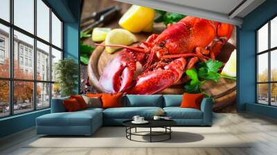 Steamed red lobster on a wooden cutting board with parsley and lemon Wall mural