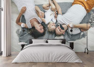 Happy beautiful young family father, mother and daughter  smiling together at home Wall mural