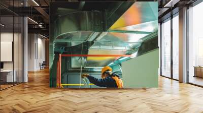 Young man in orange work vest, safety belt and hard hat going to repair HVAC system. Toned photography. Wall mural