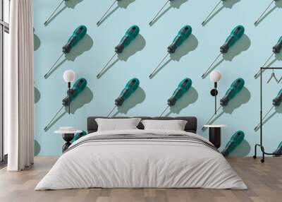 Seamless pattern of screwdrivers with a black and green handle. Wall mural