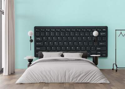 Wireless black keyboard on a light blue background. Wall mural