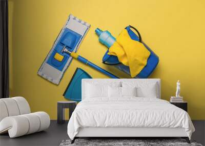 Yellow-blue cleaning kit on a bright yellow background. The concept of maintaining cleanliness. Flat lay. Wall mural